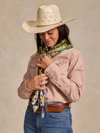 Wild rag scarf worn with pink shirt and hat; colorful cowboy-and-horse pattern neck tie.
