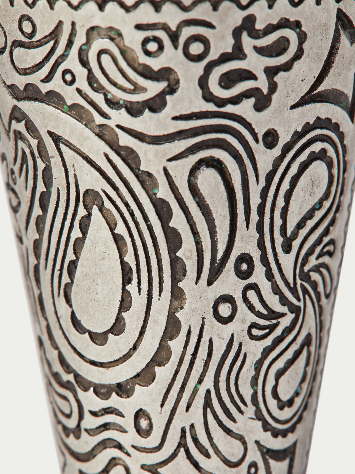 Close-up of paisley pattern on a cream cone cup with dark ornamental linework