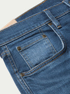 Denim dungarees waist close-up with button fly and stitched front pocket
