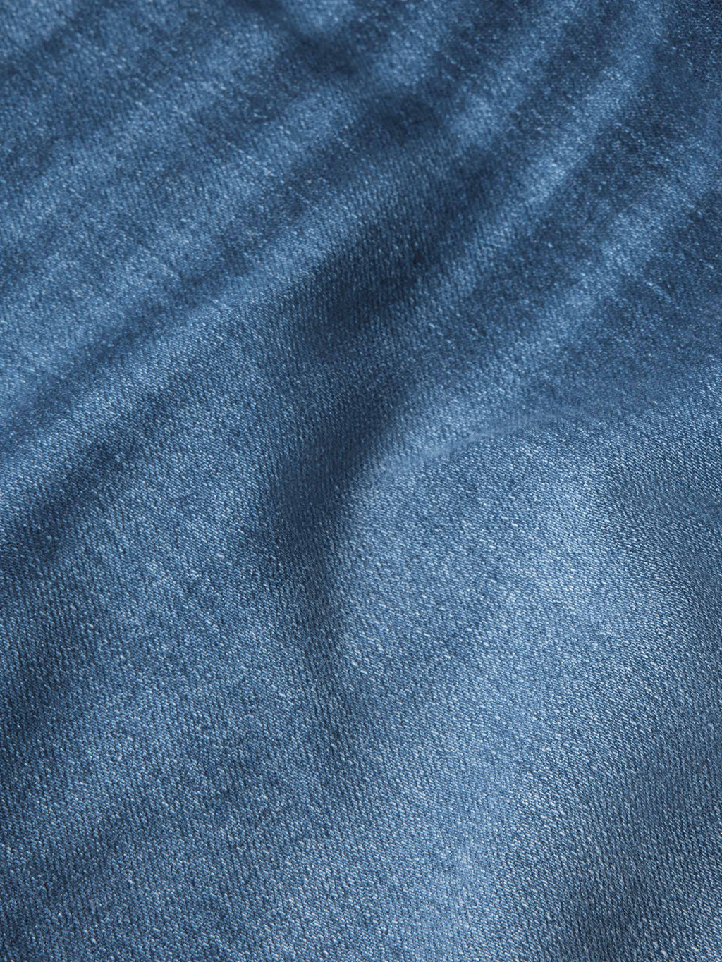 Blue denim fabric close-up showing twill texture