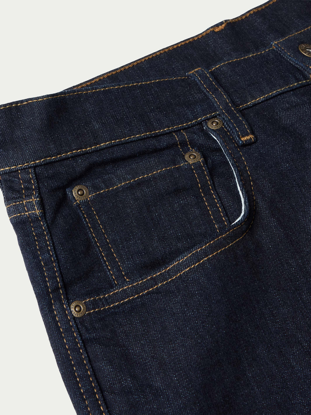 Dark rinse denim close-up of front pocket and tan contrast stitching