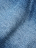 Medium-wash denim fabric texture close-up for boot-cut dungaree jeans
