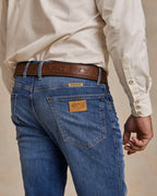 Medium-wash denim bootcut dungarees with back yoke and stitched rear pockets