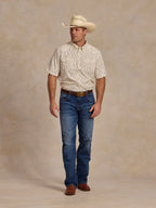 Short-sleeve pearl snap shirt on model: white with small blue floral pattern, chest pocket.