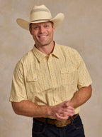 Short sleeve pearl snap western shirt in light cream pattern, worn with front button placket.