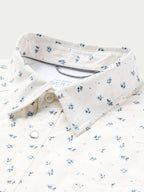 Short-sleeve pearl snap shirt collar and front placket, white with small blue floral print.