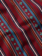 Close-up of red striped button-down with multicolor thin lines and teal geometric accents