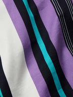 Close-up fabric detail of purple and black vertical stripes with teal accents