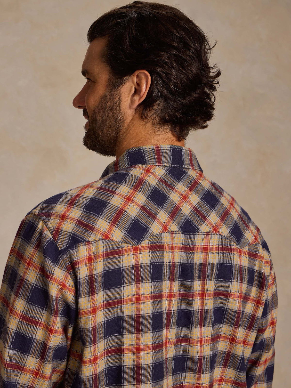 Plaid flannel button-down shirt, back view; long sleeves, navy and tan plaid.