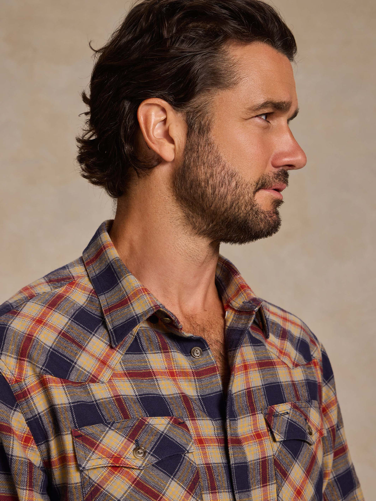 Plaid flannel button-down shirt on model: buttoned collar and two chest pockets.
