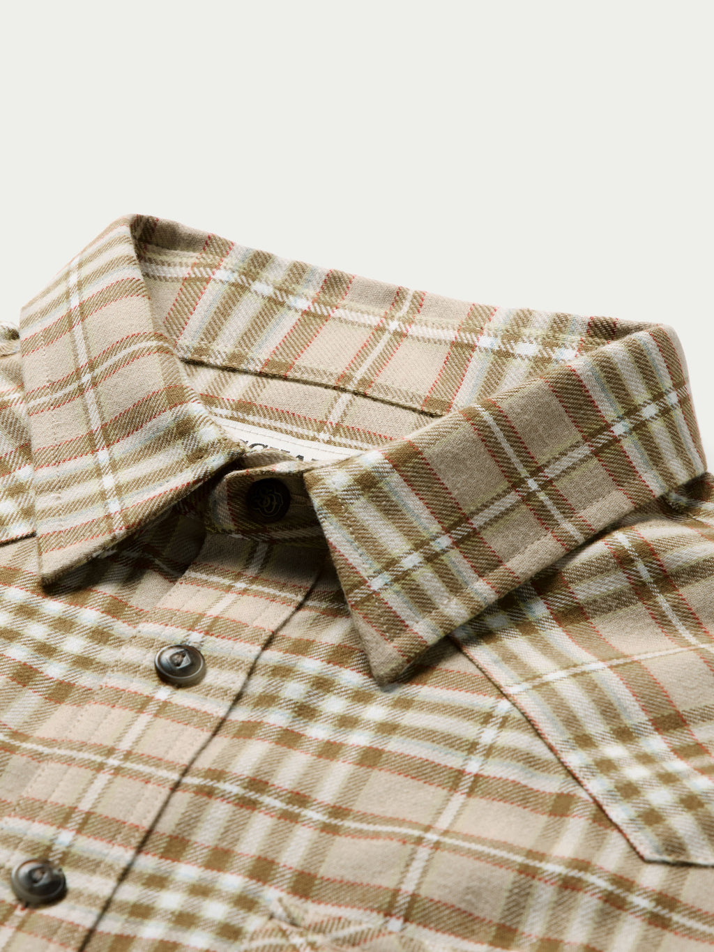 Tan plaid flannel shirt collar and button placket with dark buttons