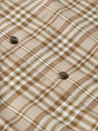 Tan plaid flannel with dark button detail on checkered fabric