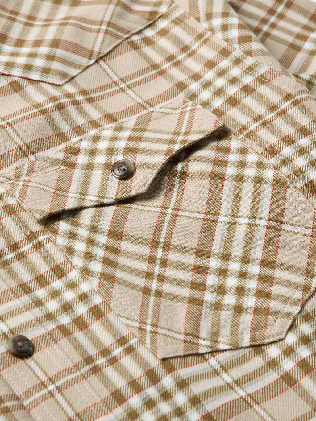 Tan plaid flannel shirt with chest pocket and dark front button