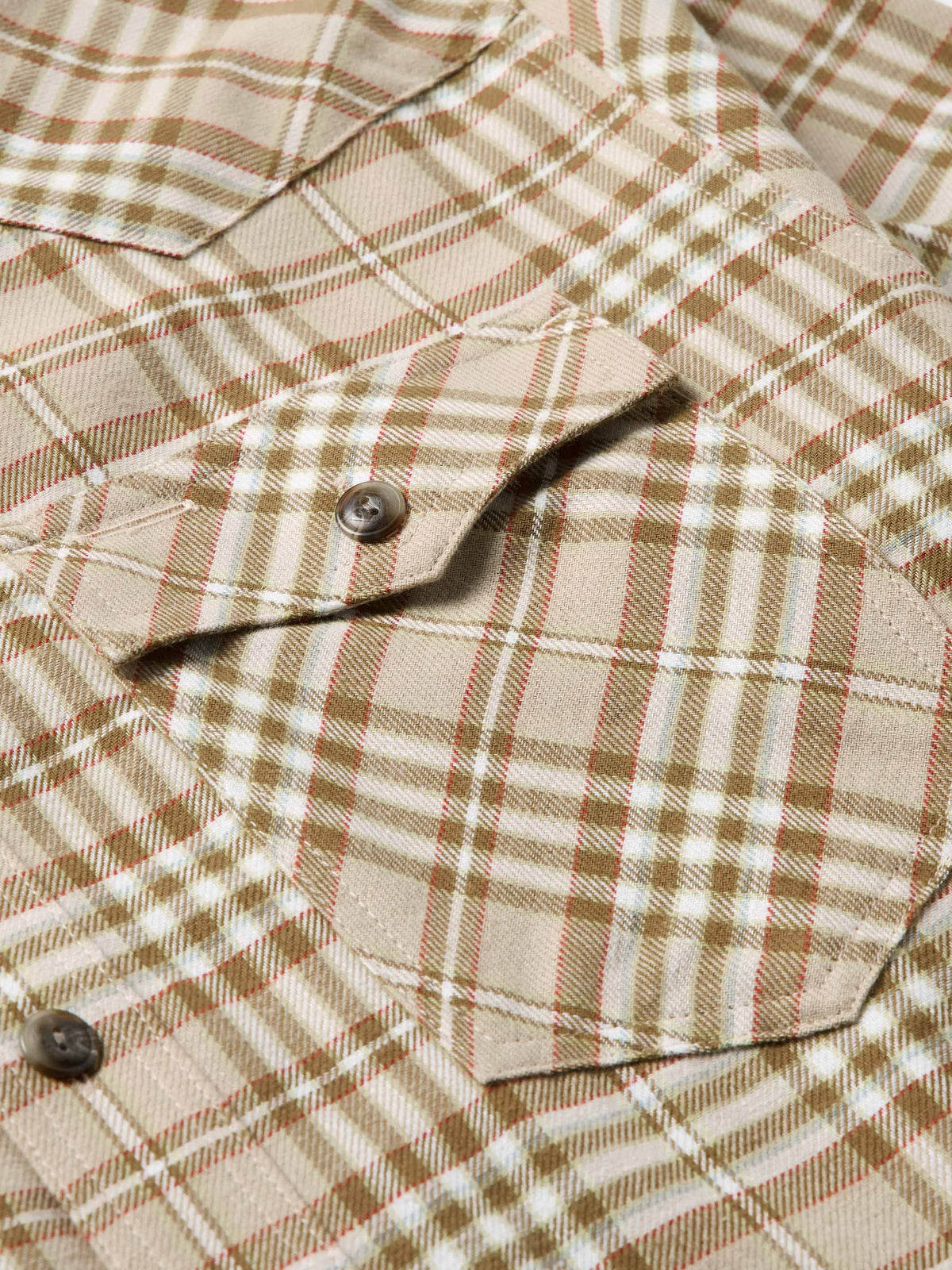 Tan plaid flannel shirt with chest pocket and dark front button