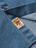 Light blue denim shirt detail with brand label patch inside collar