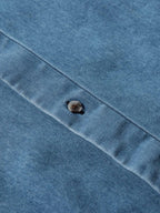 Light blue denim button-down shirt chest panel with single dark button