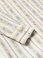 Cotton snap shirt front detail with light blue and white vertical stripes and white snap buttons