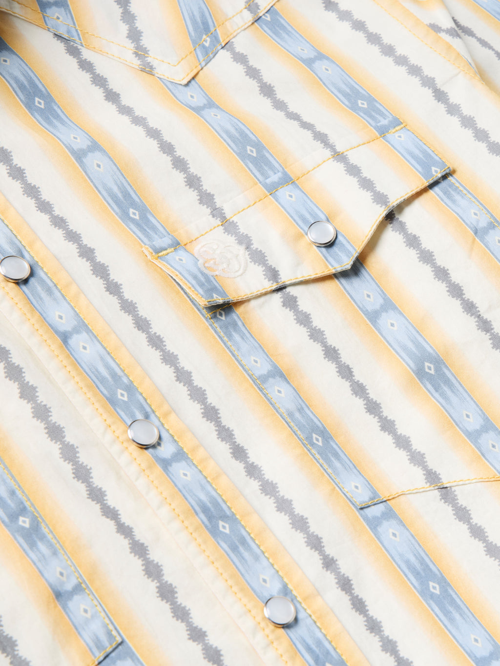 Cotton snap shirt yoke and placket detail with light blue and white vertical stripes