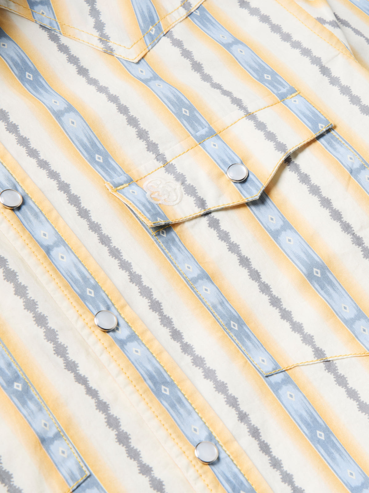 Cotton snap shirt yoke and placket detail with light blue and white vertical stripes