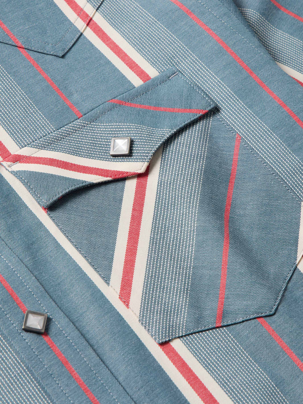 Western snap shirt yoke close-up with snap closure and red/white stripe pattern