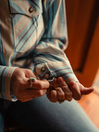 Light blue striped western snap shirt sleeve and hand adjusting snap-placket