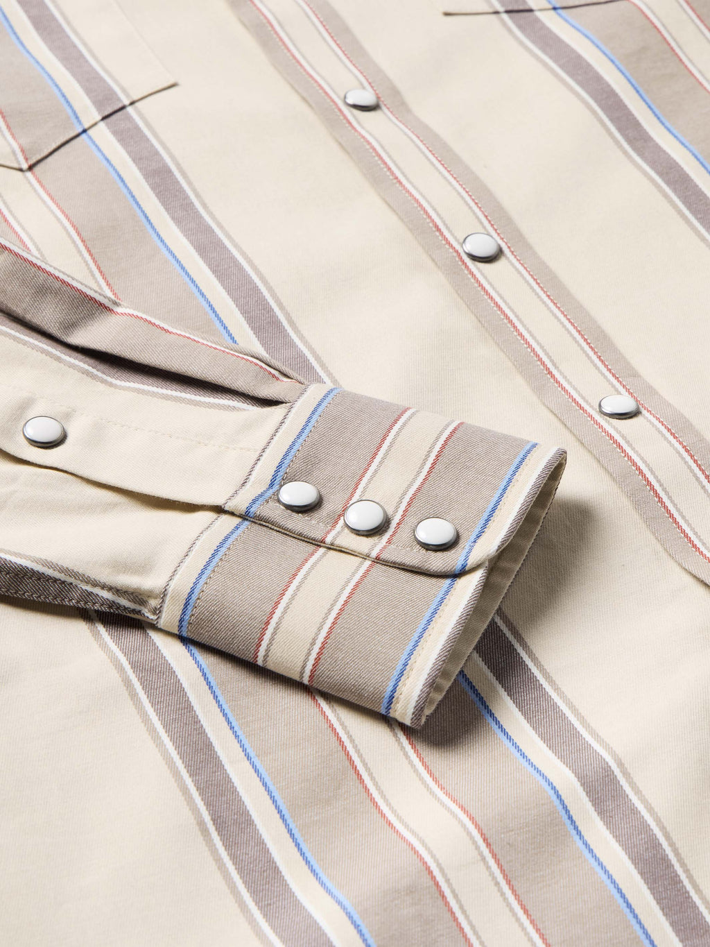 Western snap shirt in tan with blue and red vertical stripes, cuff snap detail