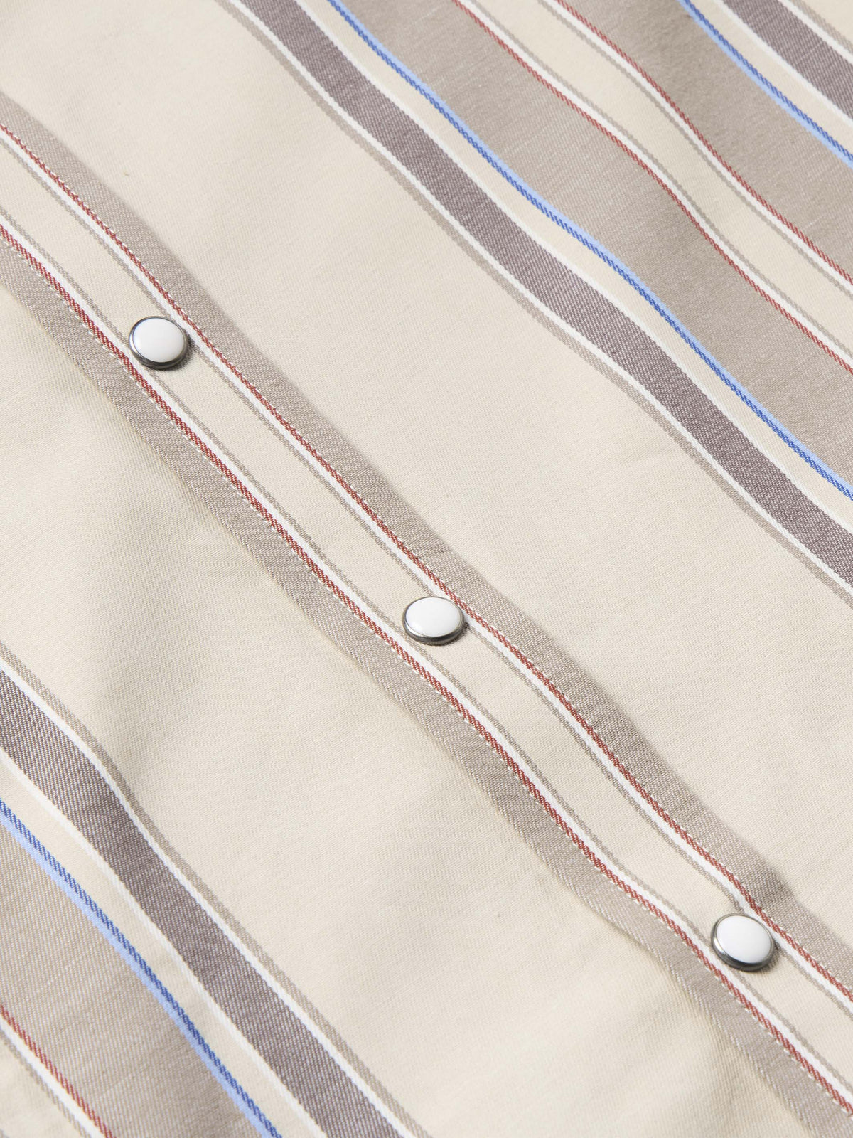 Western snap shirt in tan with blue and red vertical stripes, snap row detail