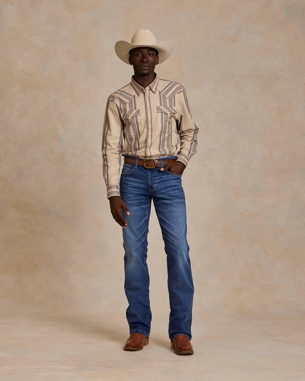 Western snap shirt in tan with blue and red stripes worn with jeans