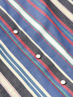 Western snap shirt sleeve detail: dark base with multicolor vertical stripe and snap buttons