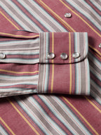 Western snap shirt cuff detail with two silver snaps on striped maroon fabric