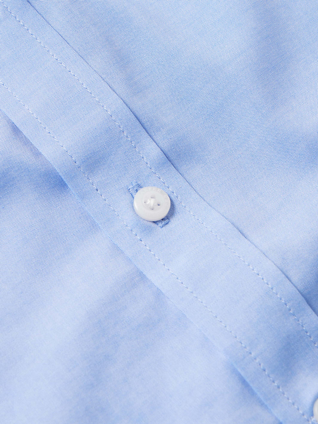 Light blue western button-down shirt placket with white button close-up