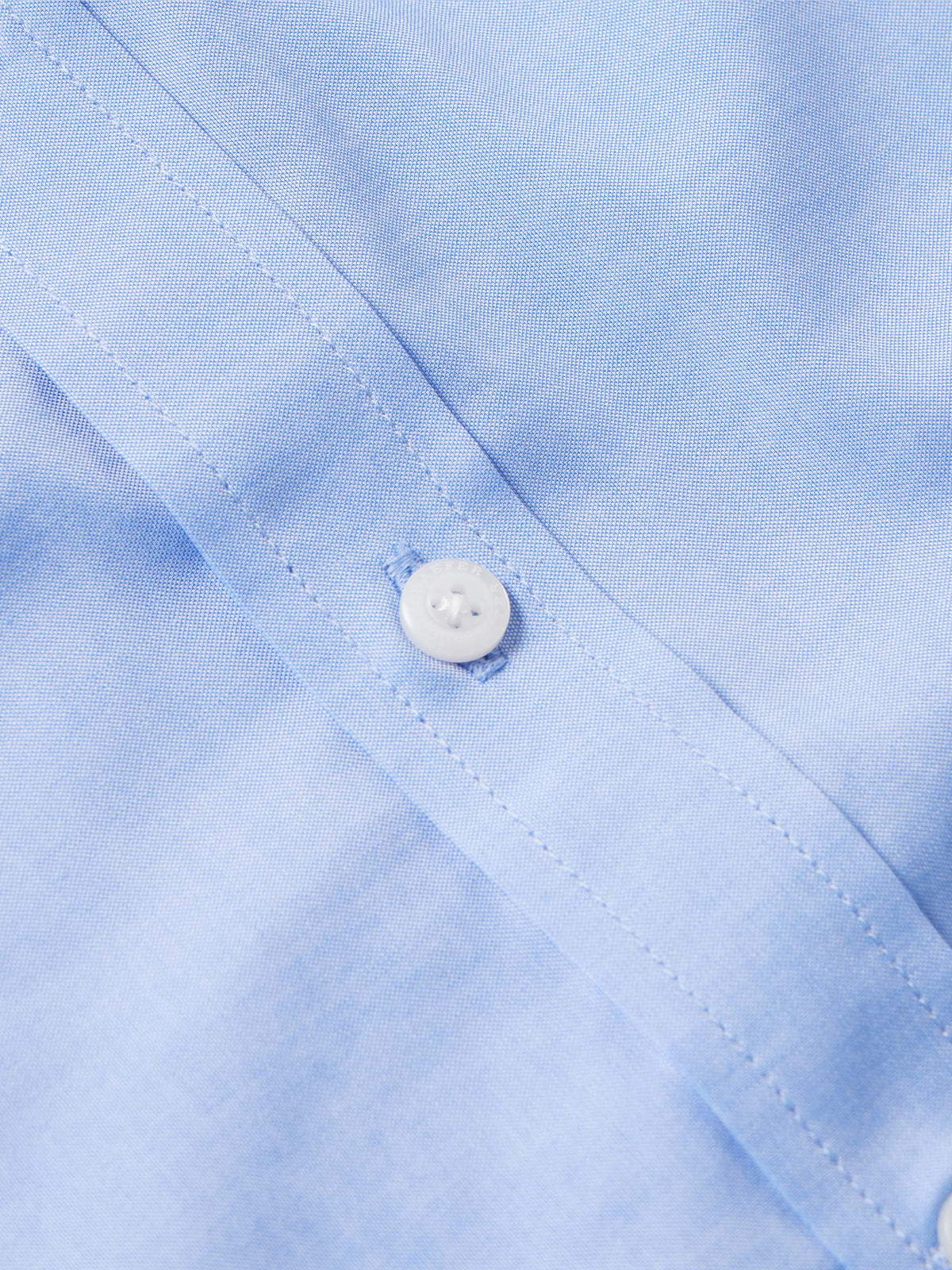 Light blue western button-down shirt placket with white button close-up