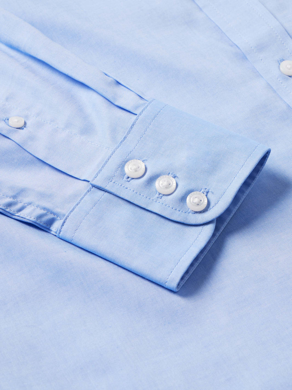 Light blue western button-down shirt cuff with two white buttons