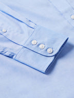 Light blue western button-down shirt cuff with two white buttons
