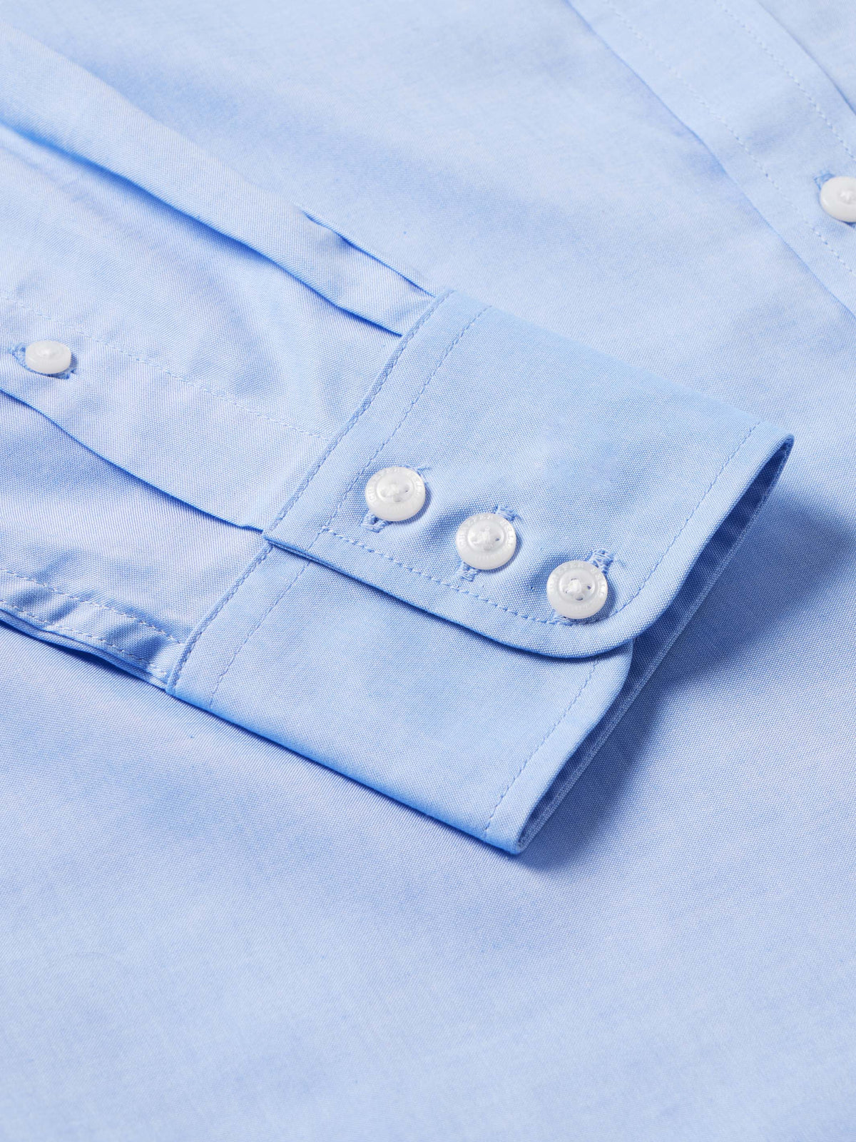 Light blue western button-down shirt cuff with two white buttons