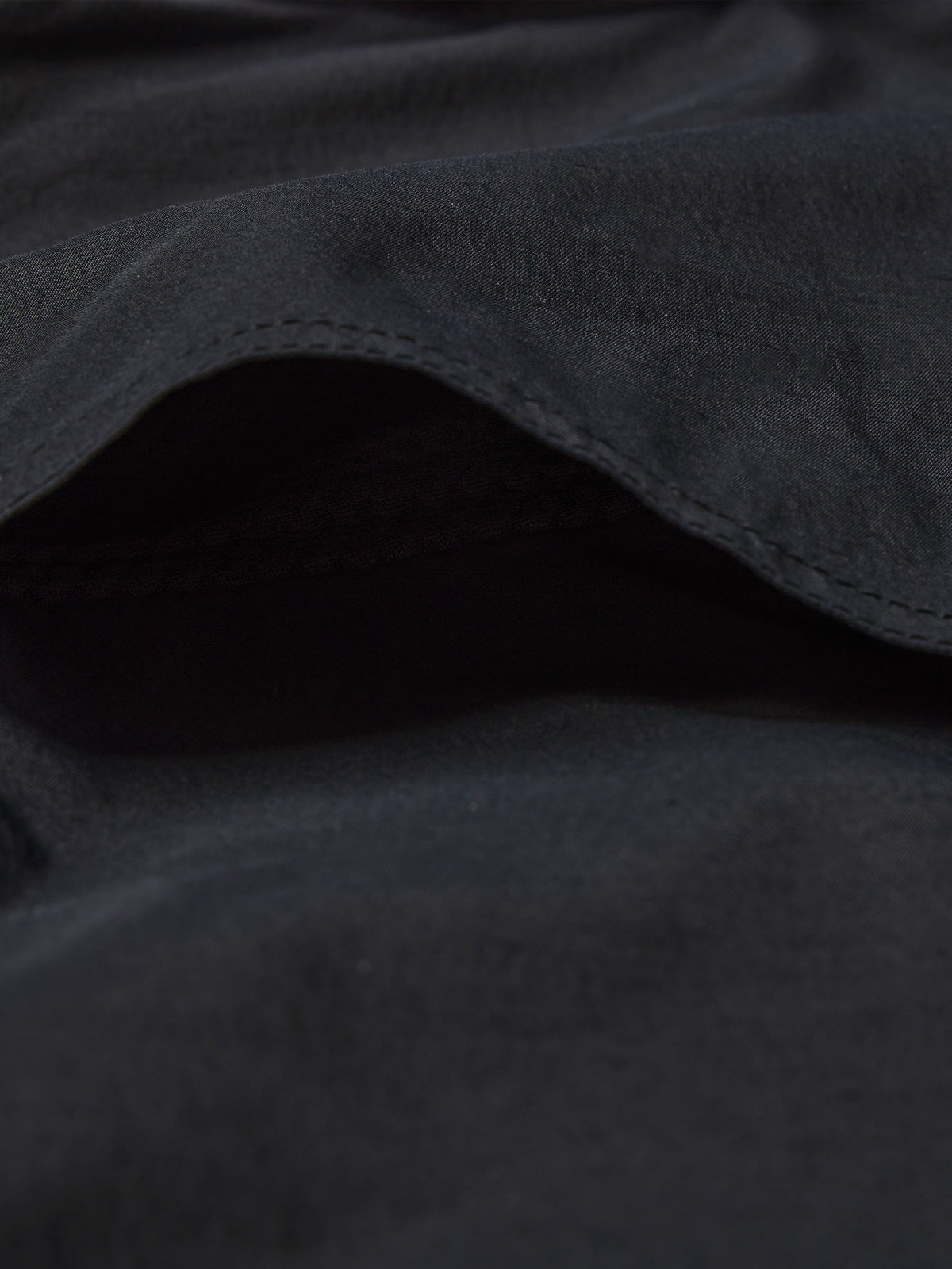 Black western snap shirt close-up of curved hem and soft fabric drape