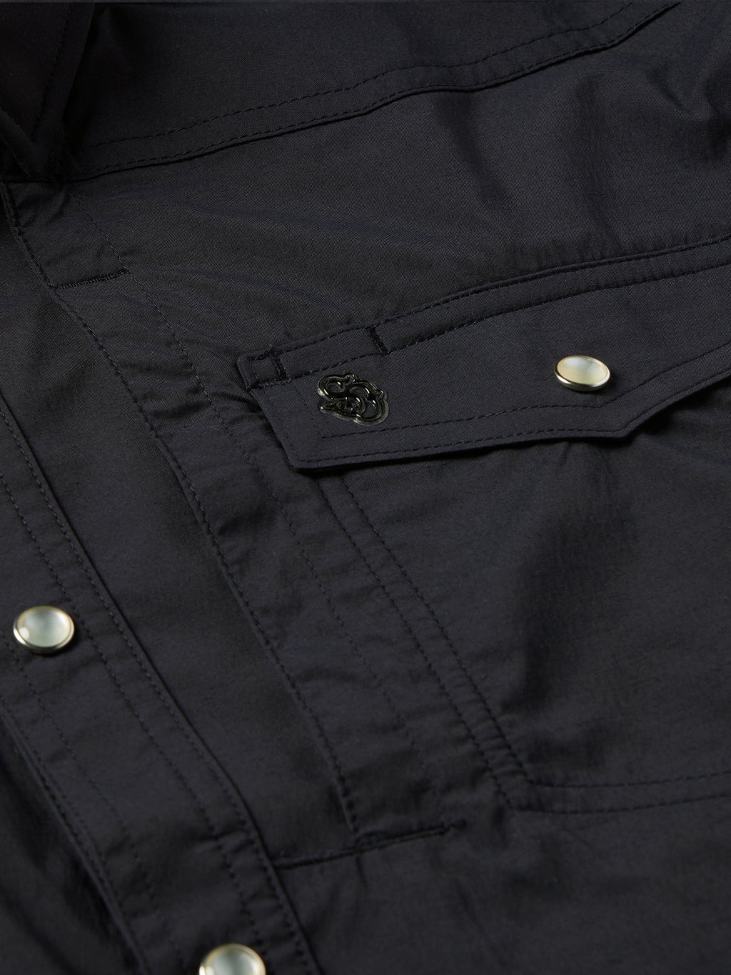Black western snap shirt close-up of chest pocket flap and embroidered patch detail