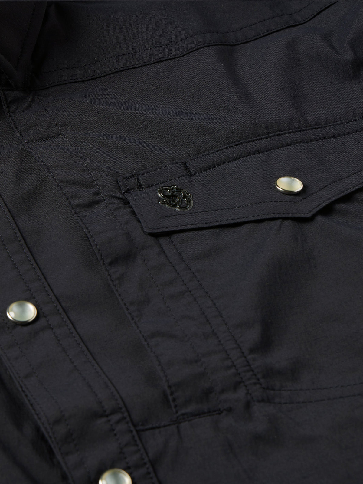 Black western snap shirt close-up of chest pocket flap and embroidered patch detail
