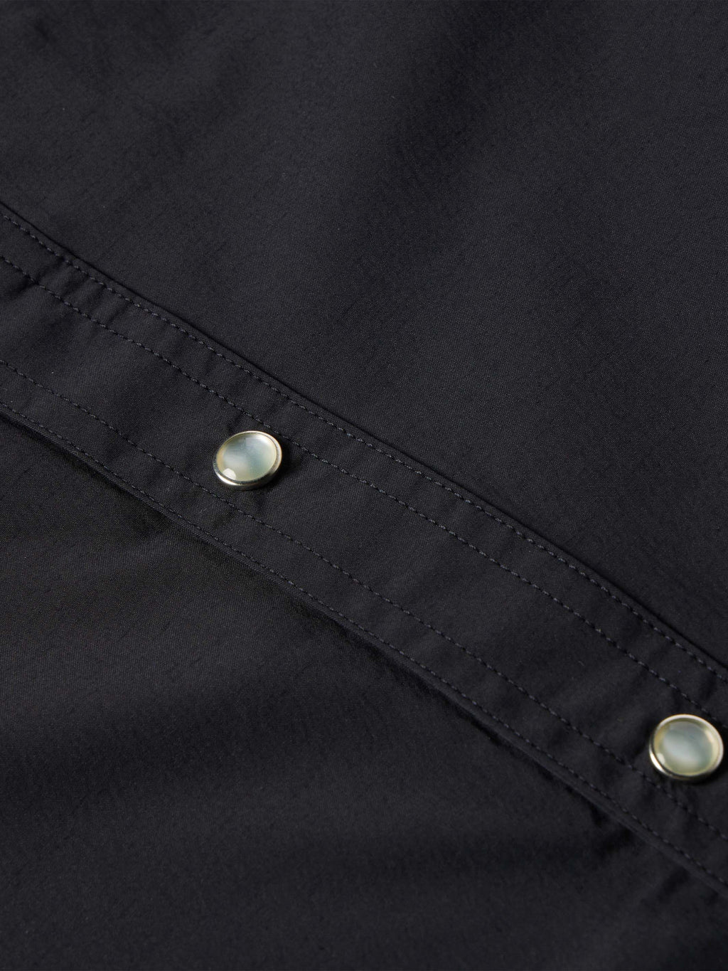 Black western snap shirt close-up of front yoke seam with two metal snaps