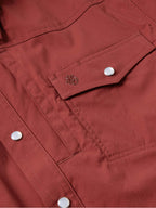 Oxblood snap pocket flap with metal snap button and visible stitching