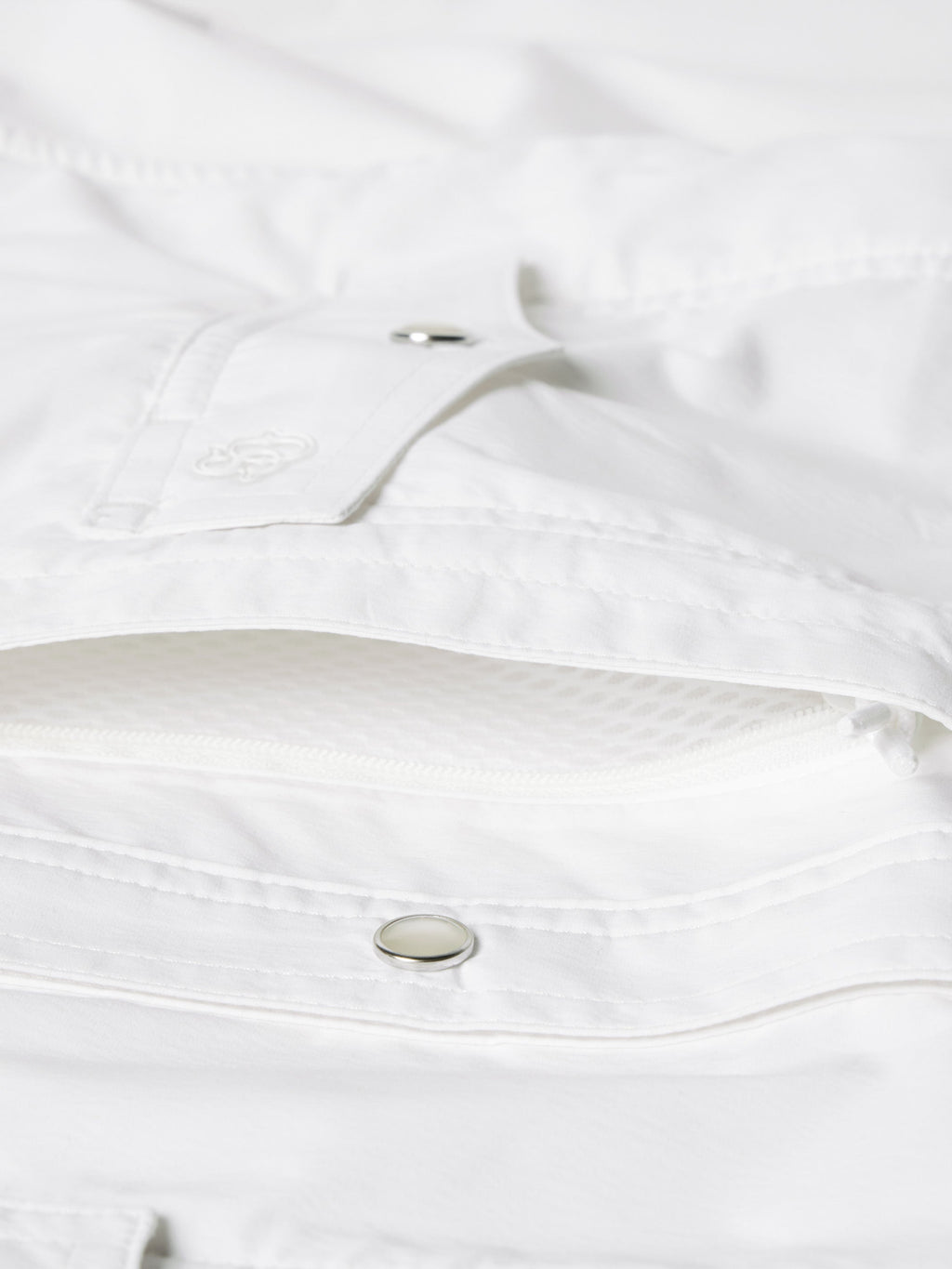 White shirt interior neckline and snap strap detail with metal snap button close-up