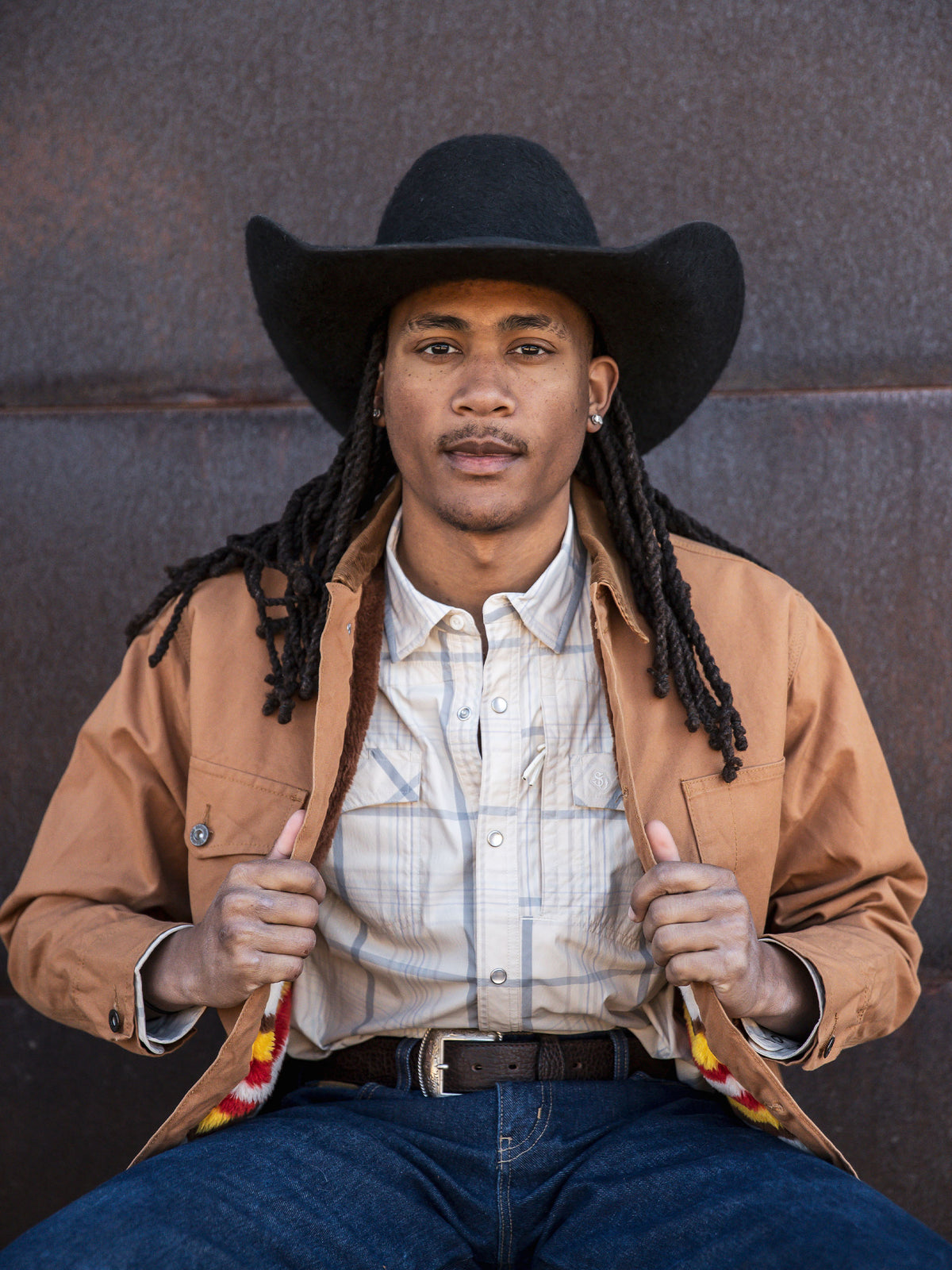 Western guide snap shirt on model, tan with light blue plaid, snap front and pockets.