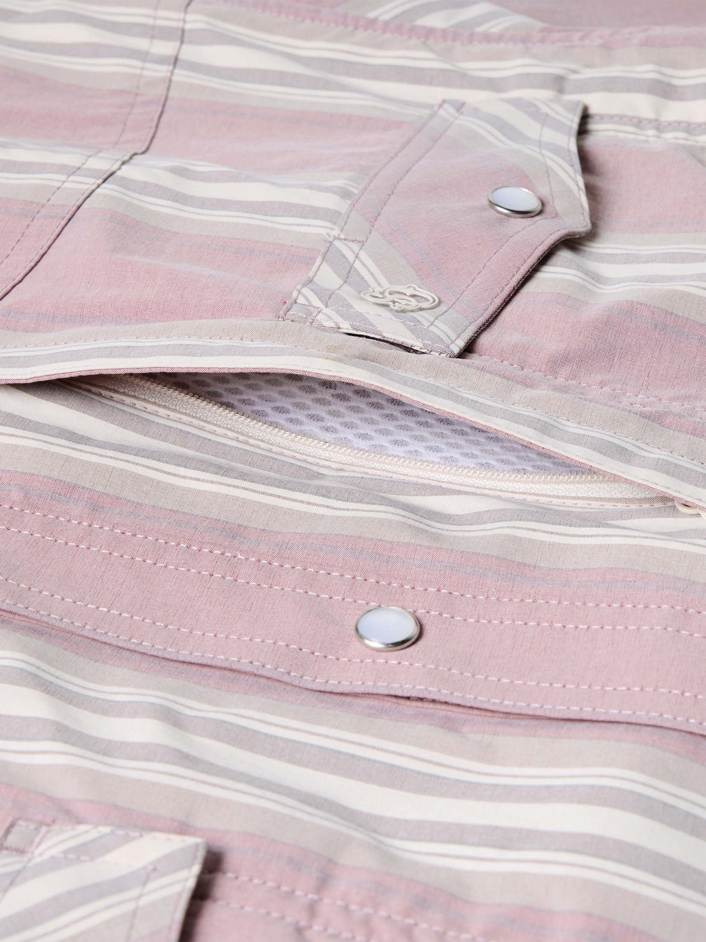 Pink striped shirt placket and button close-up with embroidered logo