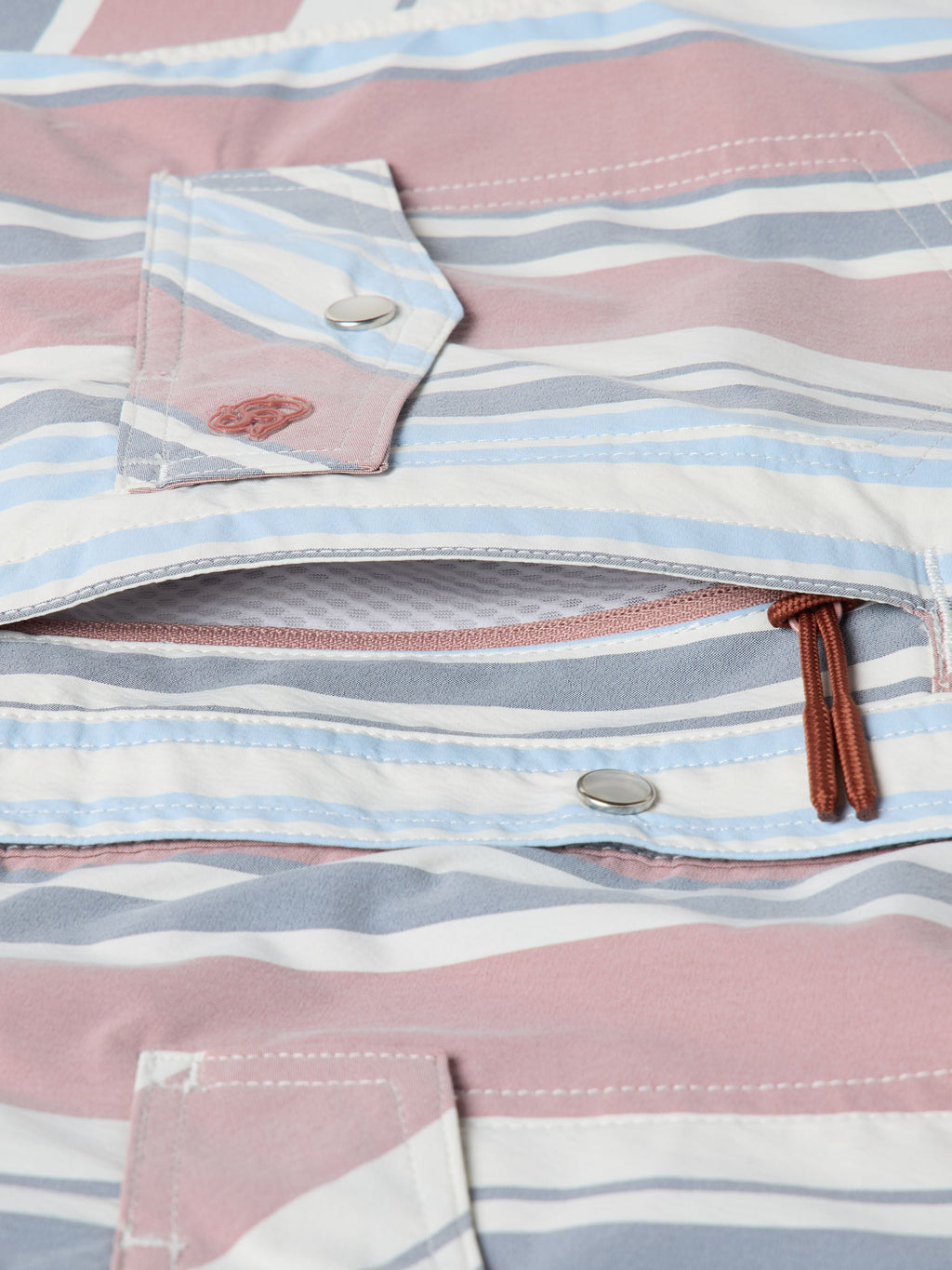 Detail of men’s striped western snap shirt showing chest pockets, snaps, and stitched placket edges
