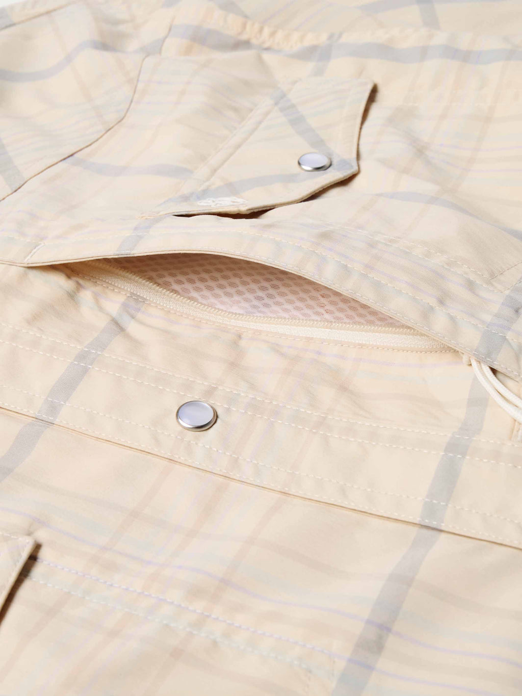 Western guide snap shirt fabric detail, cream with blue plaid, snap placket and buttons.