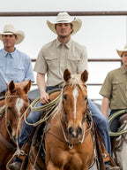 Khaki short-sleeve Western snap shirt worn by cowboy near horses
