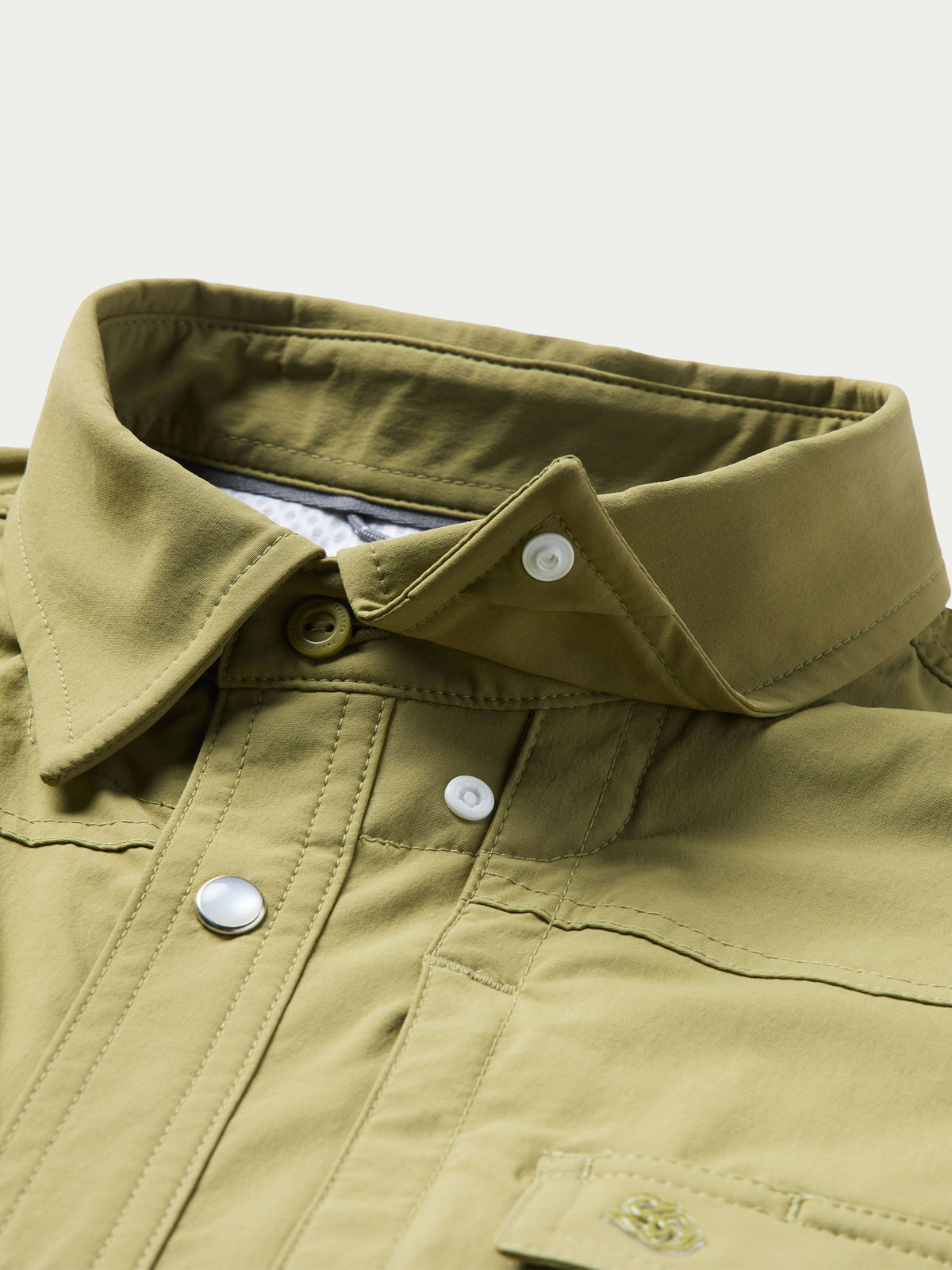 Olive short-sleeve snap western shirt close-up of chest yoke, button snaps, pocket
