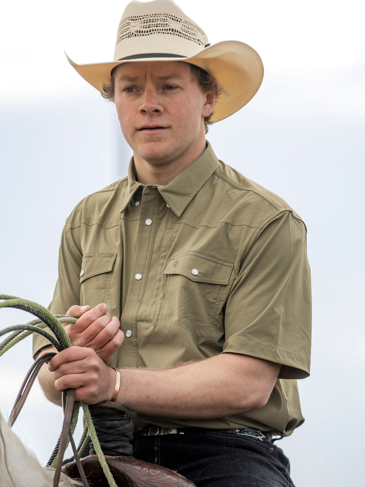 Olive short-sleeve snap western shirt worn by model, front view with chest pocket