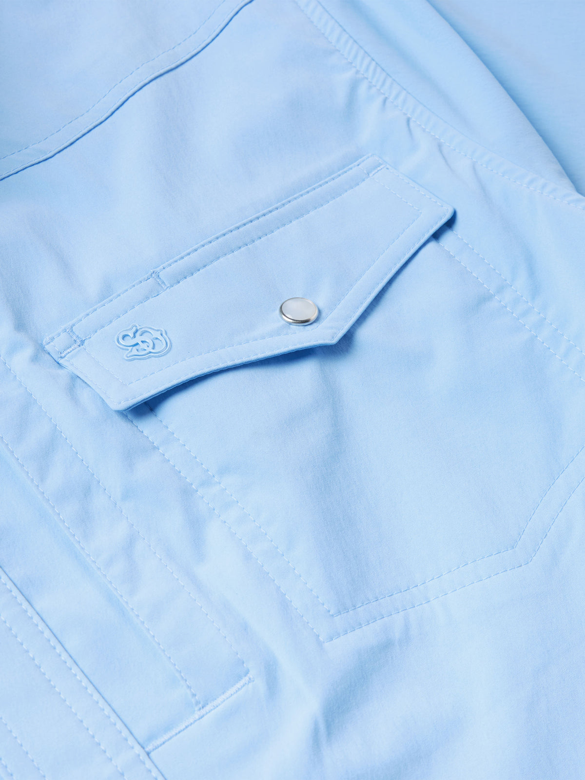 Close-up of sky blue chest pocket flap and metal snap