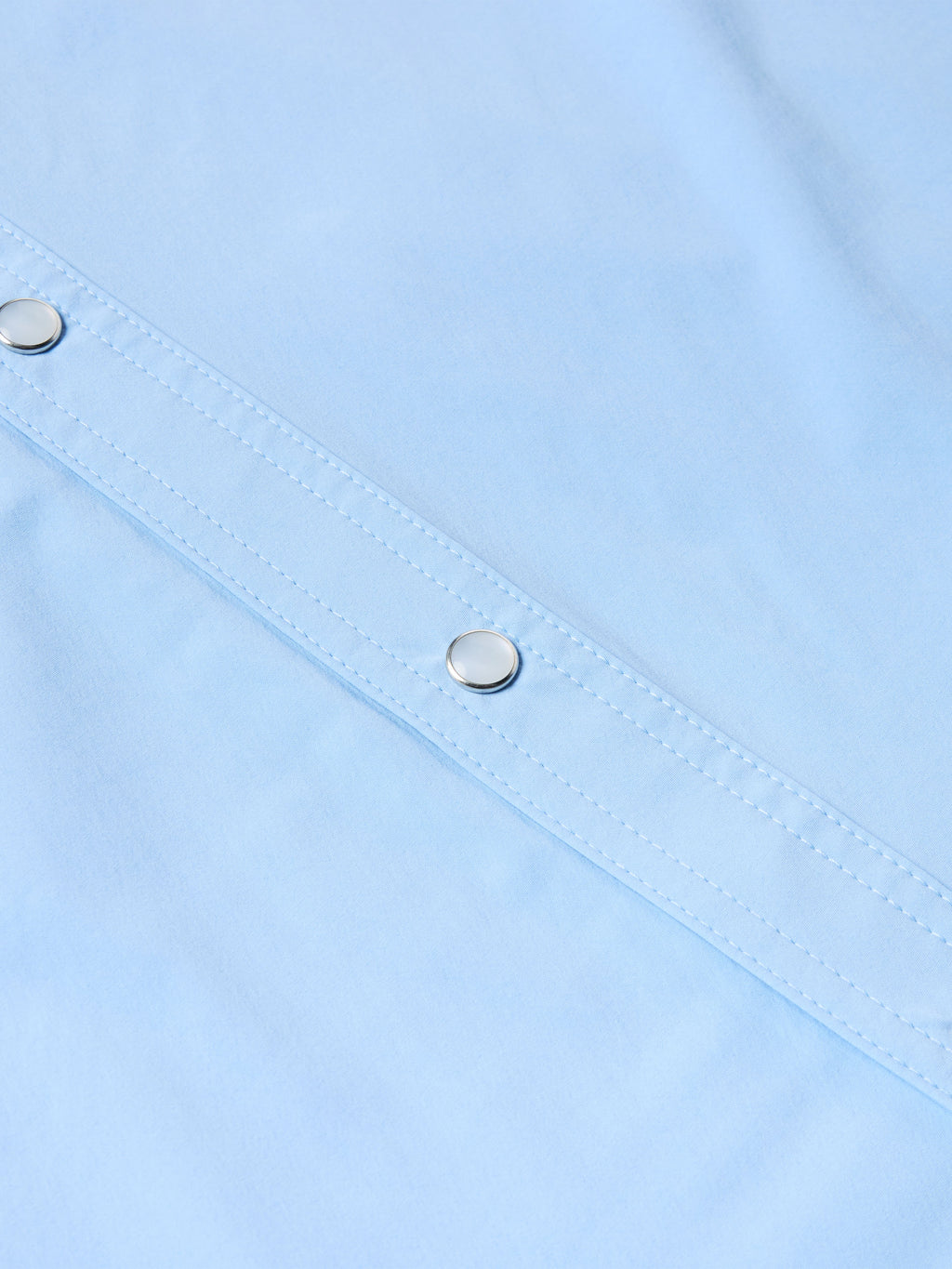 Light blue short-sleeve snap shirt placket with metal snaps and stitched seams